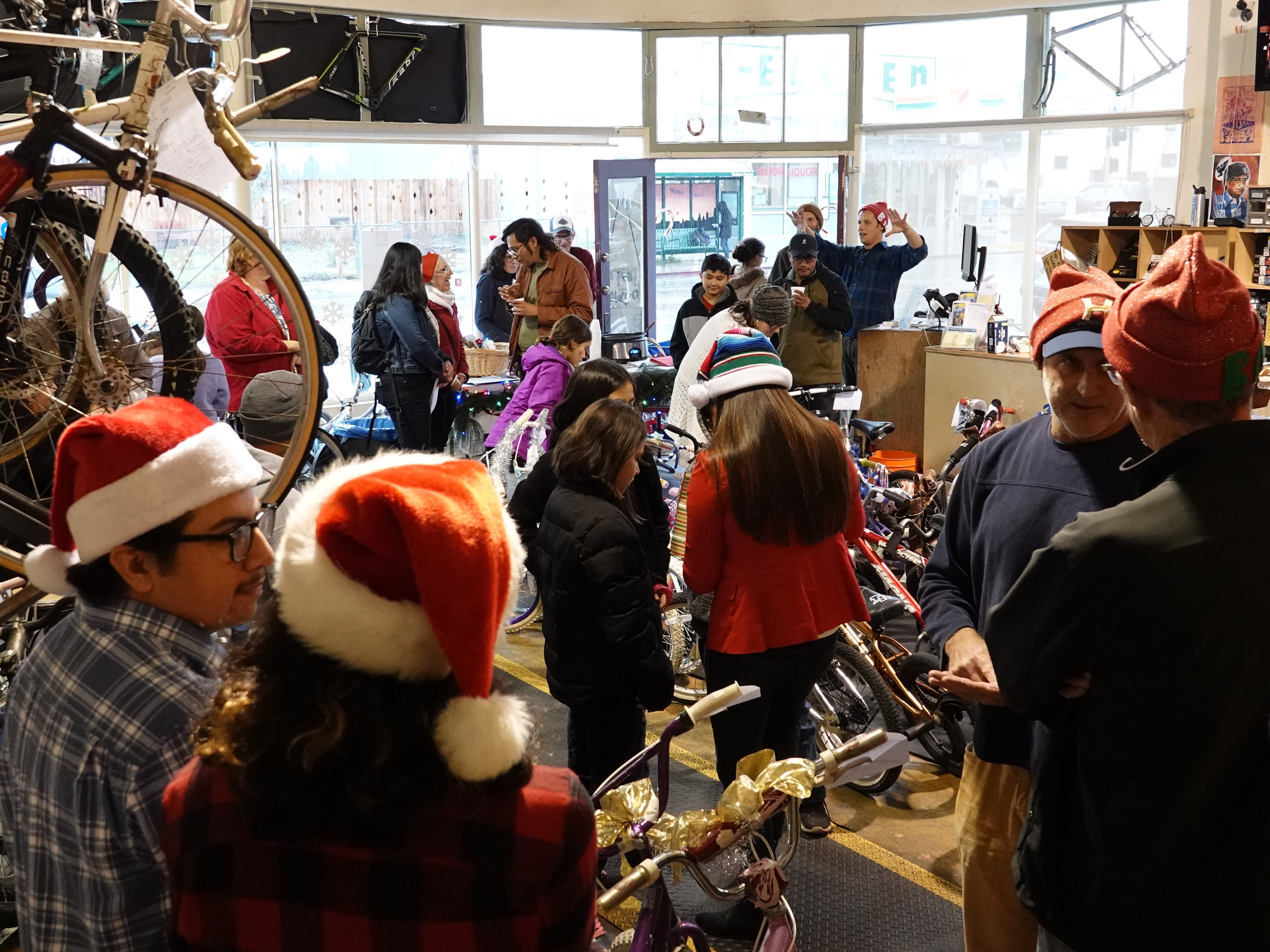 Santa Claus hats were part of the seasonal decor during a holiday bike giveaway at Ventura Bike HUB on Sunday. Staff and volunteers from the nonprofit shop spent months fixing up about 30 bikes to give to local kids in need.