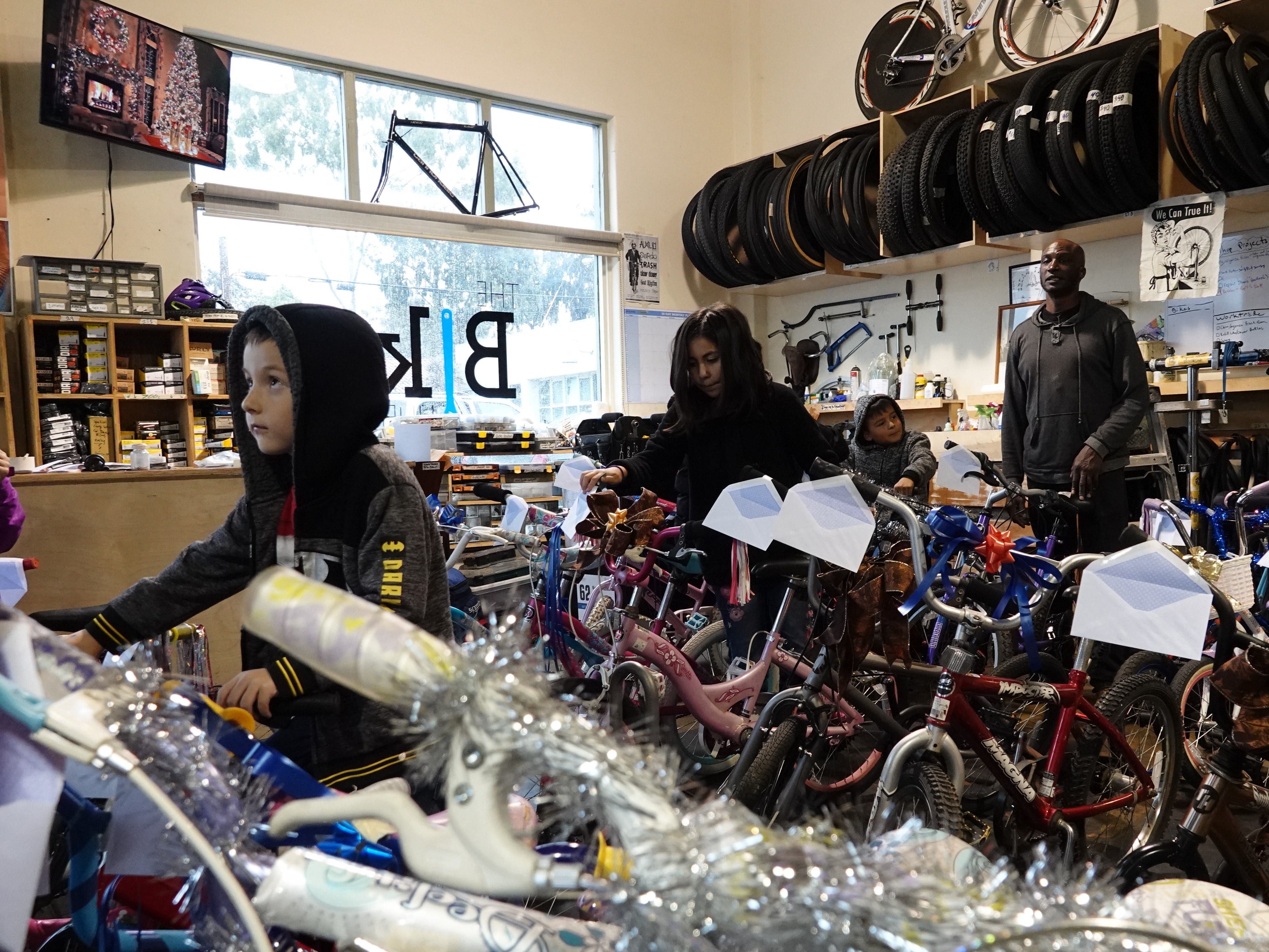 Kids check out bicycles before the holiday bike giveaway Sunday at Ventura Bike HUB. The nonprofit shop fixed up about 30 bikes to give out to local children in need.