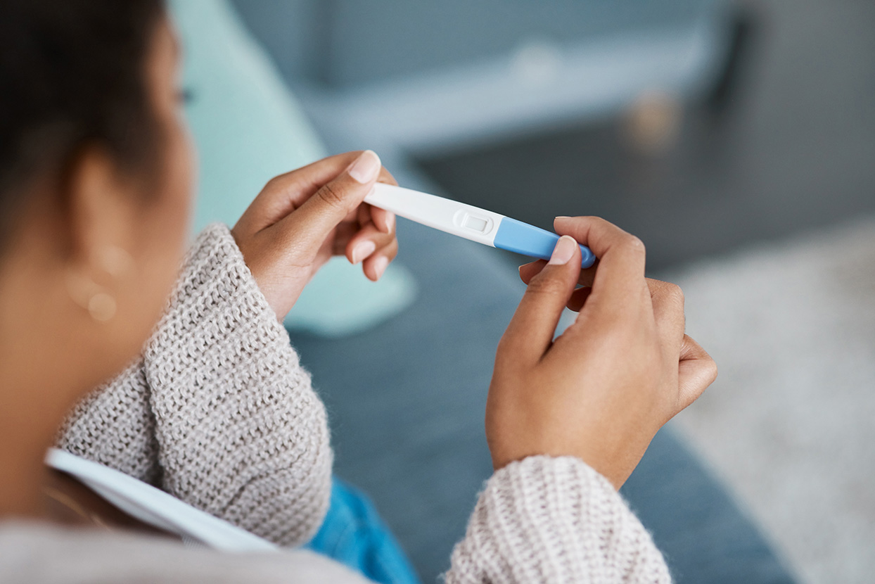 A woman looking at a pregnancy test