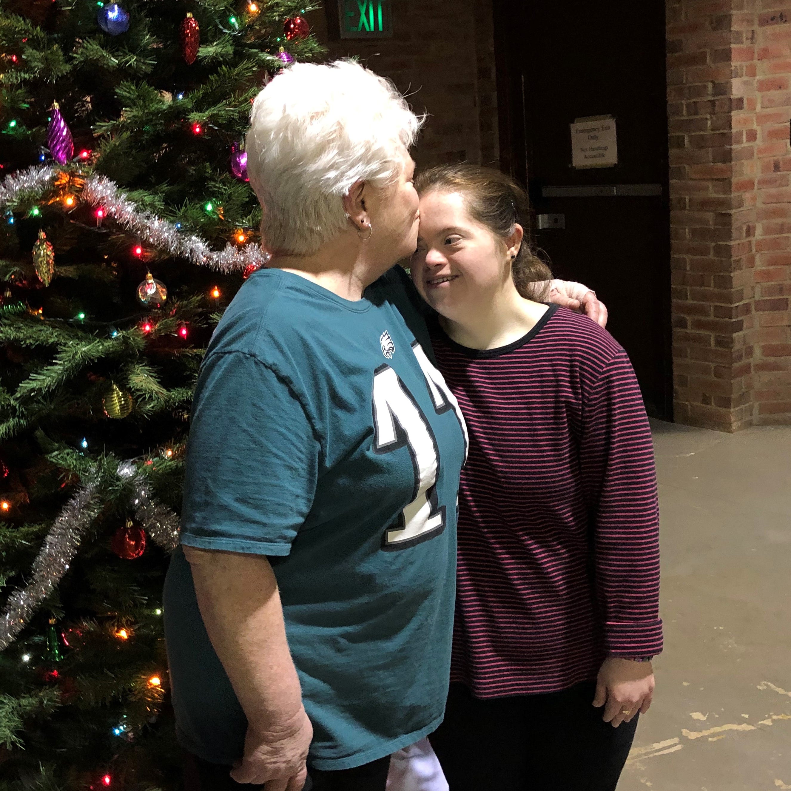 JoAnn McNamee plants a kiss on the forehead of her daughter Katie. McNamee founded the nonprofit program Kate's Place 12 years ago to provide an outlet for Katie and other adults with special needs.