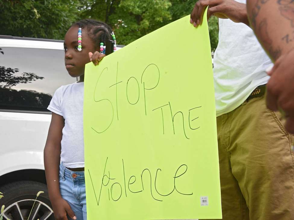 Angel Maria Stokes,7, holds a sign with her brother Shy'reed Wofford as anti-violence activists hold a rally at Third Avenue and Elizabeth Street near where a sleeping child was hit with a stray bullet last week on Tuesday, July 23, 2019 in Albany, N.Y. Albany 518 SNUG organized the gathering. (Lori Van Buren/Times Union)