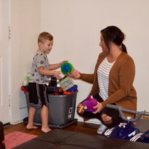 Alexa Bihner and Ryder putting toys away