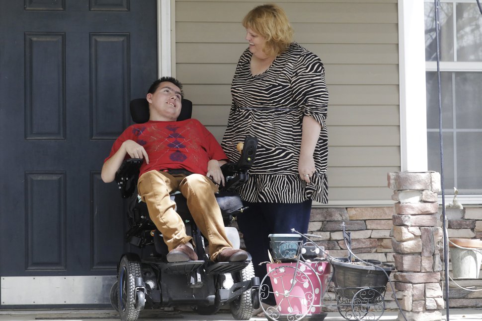 (Rick Bowmer | AP) In this April 14, 2020, photo, Jodi Hansen talks with her son Jacob Hansen at their home, in Eagle Mountain, Utah. Even before the new coronavirus hit, cystic fibrosis meant a cold could put Jacob Hansen in the hospital for weeks. He relies on hand sanitizer and disinfecting wipes to keep germs at bay because has cerebral palsy and uses a wheelchair, but these days shelves are often bare. For millions of disabled people and their families, the coronavirus crisis has piled on new difficulties and ramped up those that already existed.