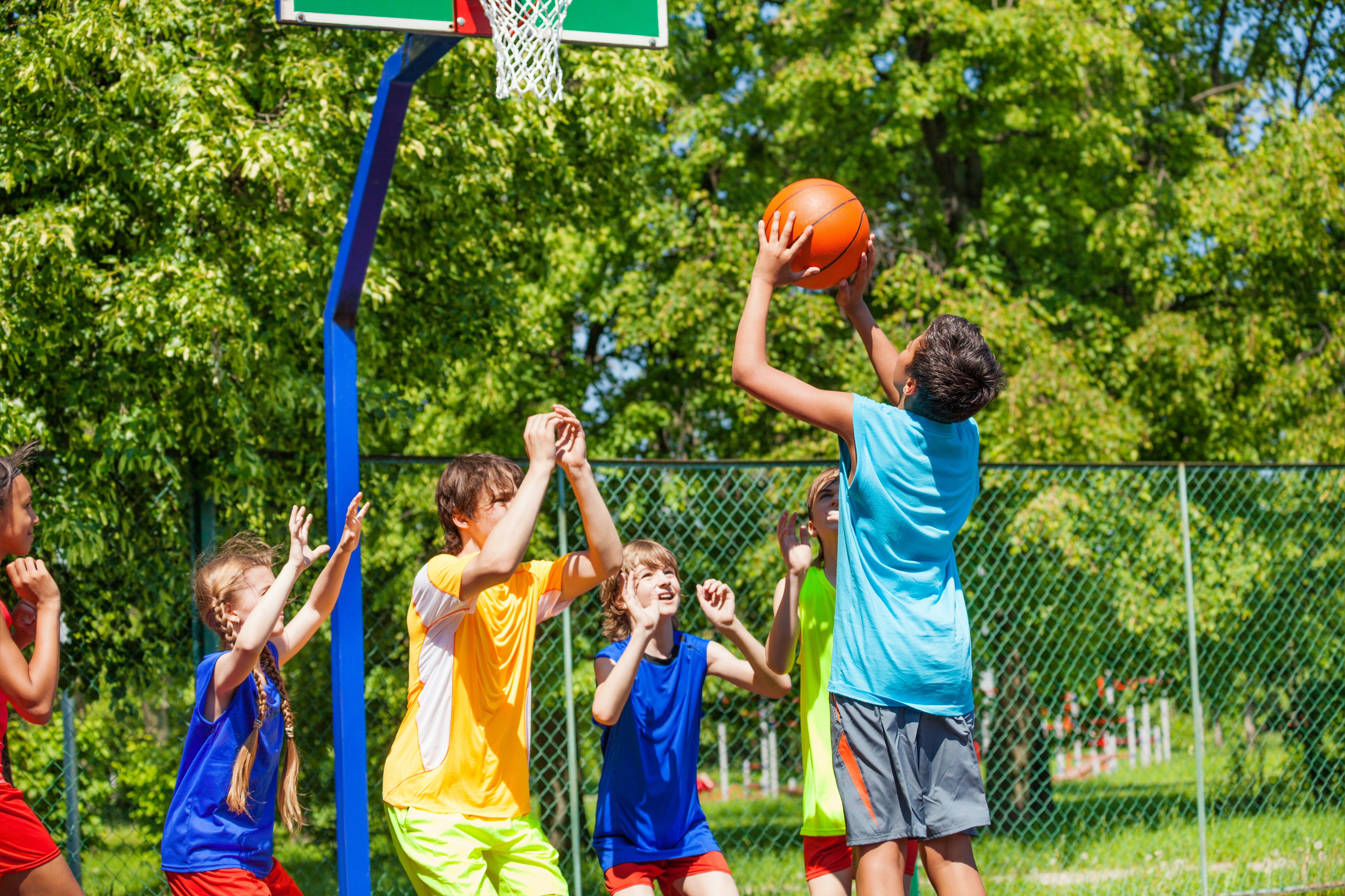 Groups of teens playing basketball.