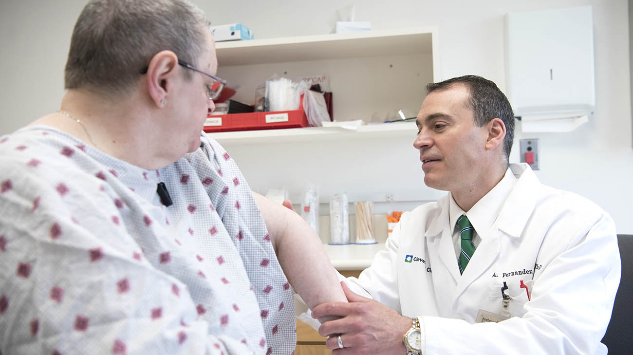 Dr. Anthony Fernandez examines patient's classic dermatomyositis skin condition. 