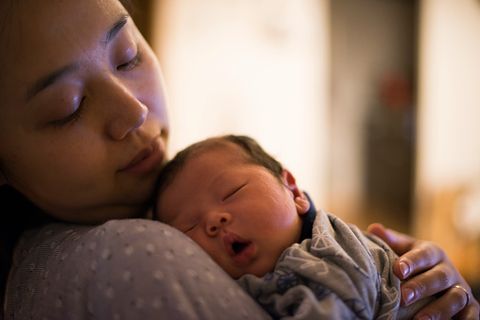 a mother looks his newborn baby gently