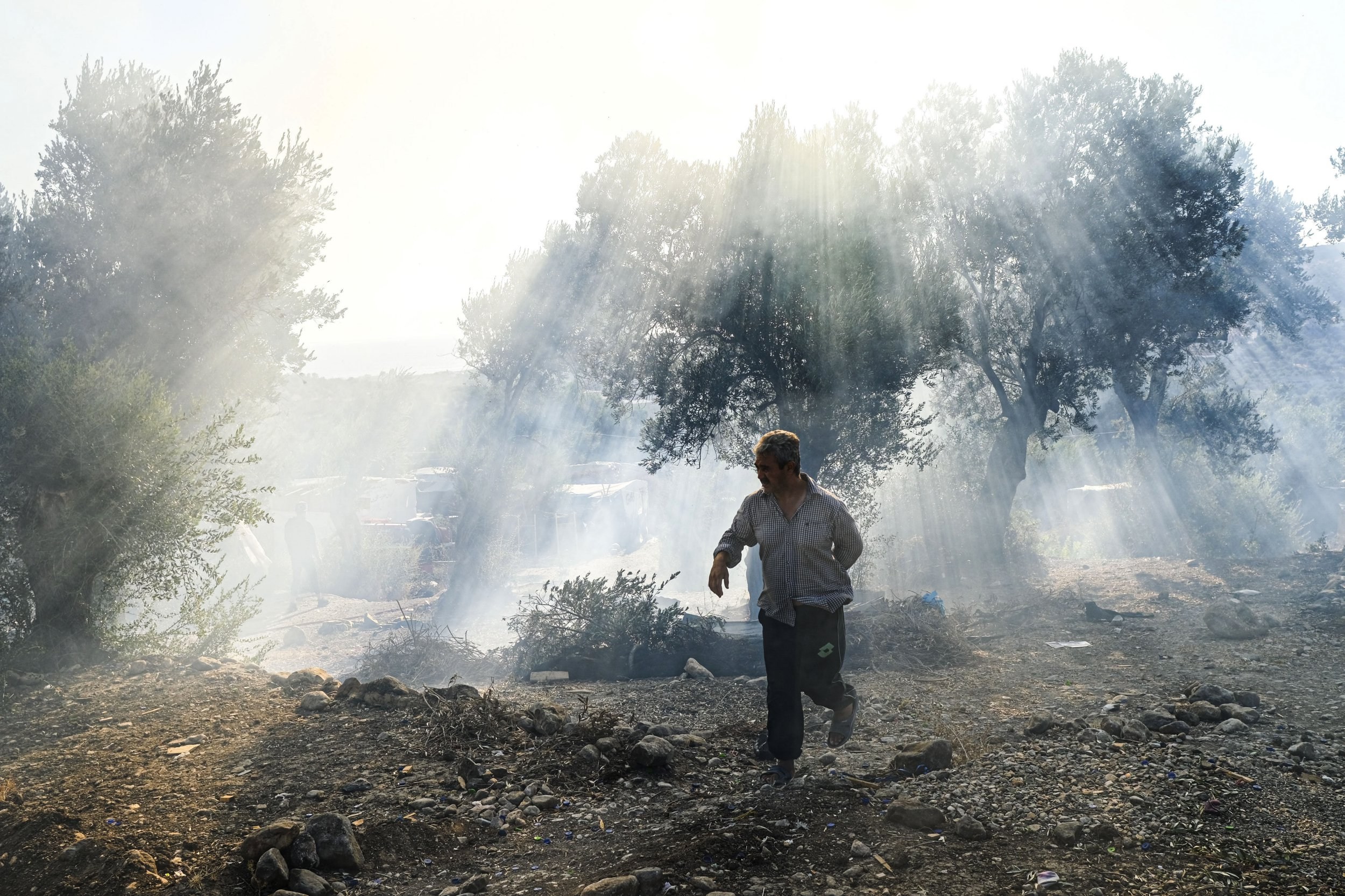 A boy runs through what remains of Moria camp.