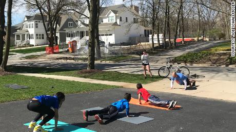 Joe Schallmoser (far right), athletic director at Avery Coonley School in Downers Grove, Ill., traveled to his students&#39; homes to do burpees in their driveways while social distancing.